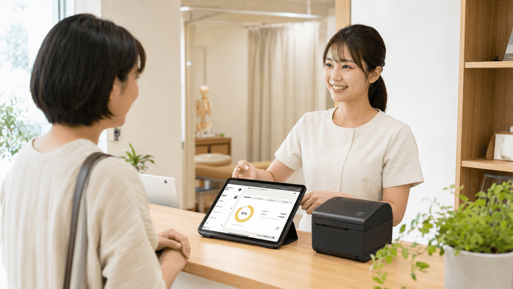 整骨院の受付でPOS＋ healthcareを使用するスタッフ